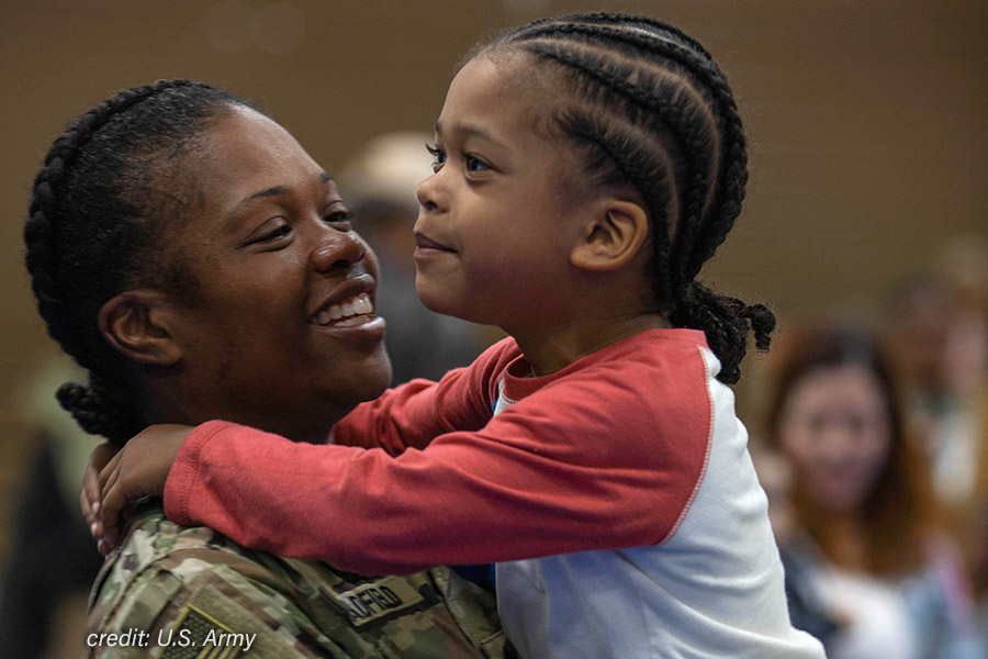 U.S. Army soldier smiling and holding her child