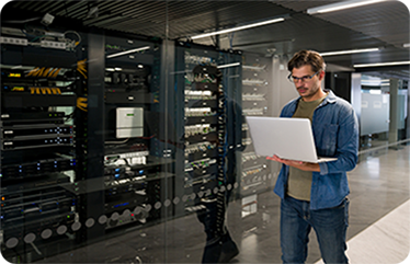 IT support technician fixing a network server using a laptop computer